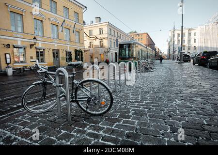 Helsinki, Finlandia 20 novembre 2020 centro di Helsinki, Piazza del Senato, tram verde e biciclette nel parcheggio coperto di neve, giorno di sole a novembre. Foto di alta qualità Foto Stock
