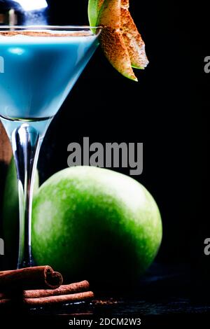 Cocktail con liquore, crema e mela verde, strumenti da bar su sfondo nero, concentrazione selettiva Foto Stock