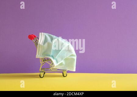 Carrello con maschera medica protettiva. Spazio di copia. Acquisto sicuro e online sul concetto di quarantena. Foto Stock