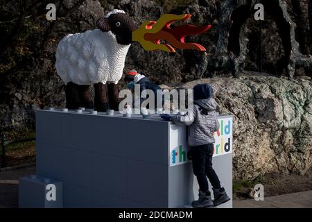 Cracovia, Polonia. 21 Nov 2020. I bambini giocano sulla scultura.UNA pecora che respira il fuoco di Lego è stata collocata a Cracovia, proprio accanto alla scultura del drago di Wawel, come parte dell'azione globale RebuildTheWorld che mira a sviluppare la creatività dei bambini. Credit: SOPA Images Limited/Alamy Live News Foto Stock