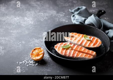 Bistecche di salmone grigliate in padella di ghisa, focalizzazione selettiva Foto Stock