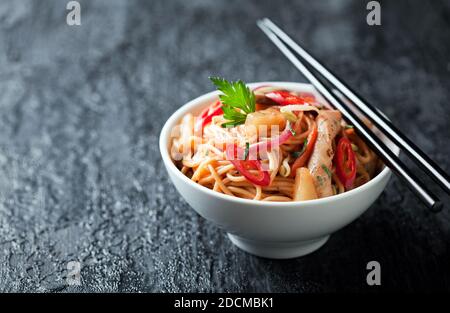 Tagliatelle con verdure, pollo e ananas in salsa dolce e agrodolce, fuoco selettivo Foto Stock