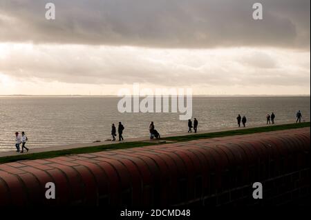 Wilhelmshaven, Germania. 22 novembre 2020. Gli escursionisti camminano lungo il lungomare sulla spiaggia sud. Credit: Mohssen Assanimoghaddam/dpa/Alamy Live News Foto Stock