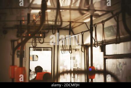 Un abitacolo vuoto di un autobus pubblico dall'interno, con luce che brilla attraverso le finestre trasparenti. Trasporti pubblici. Foto Stock