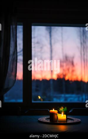 Candele sul tavolo, cielo tramonto sullo sfondo. Foto Stock