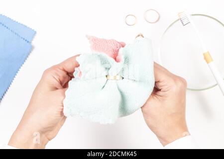 Donna mani pulizia e lucidatura gioielli dorati a casa. Vista dall'alto Foto Stock