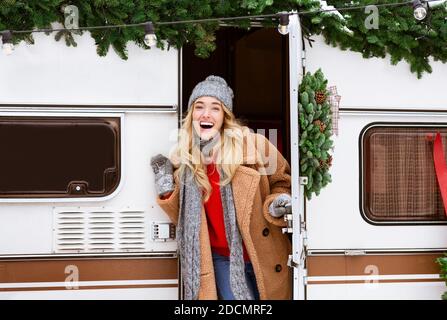 Viaggi invernali. Emozionante Blonde Woman uscire di Campervan moderno, campeggio all'aperto Foto Stock