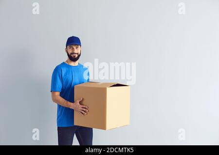 Buon corriere maschio sorridente per la macchina fotografica Foto Stock
