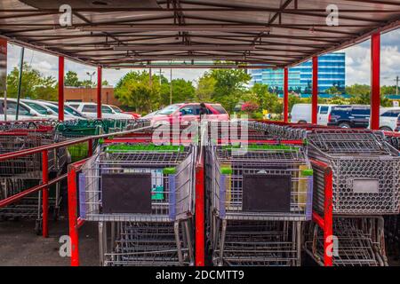 Gwinnett County, GA / USA - 07 08 20: File di carrelli per lo shopping in una struttura a carrello rosso Foto Stock