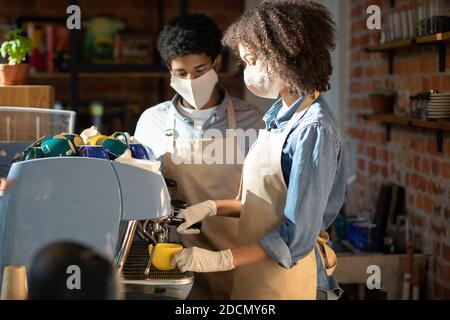 Il barista lavora durante il distanziamento sociale e la pandemia del covid-19 Foto Stock