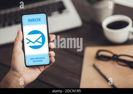 Collage con la mano femminile che mostra cellulare con busta e-mail e notifica di nuovo messaggio sullo schermo, spazio di copia Foto Stock