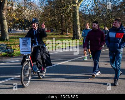 Londra, Regno Unito. 22 novembre 2020. Un uomo con un casco in polio sulle proteste per la chiusura degli altoparlanti angolo a causa delle nuove restrizioni. Evade l'arresto ciclando intorno al parco. Hyde Park durante il secondo Lockdown Coronavirus. Credit: Guy Bell/Alamy Live News Foto Stock