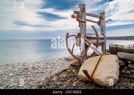 Derelict vecchio verricello barca sulla spiaggia di ciottoli a Jordhamn storico, Öland, Svezia. Foto Stock