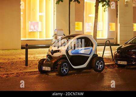 Berlino, Germania - 16 agosto 2020: Vista su un'auto elettrica che viene caricata in una stazione di ricarica pubblica di notte. Foto Stock