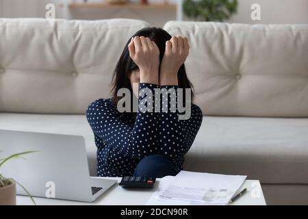 Primo piano depressa donna asiatica che controlla le bollette, il debito o il fallimento Foto Stock