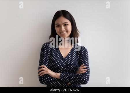 Testa ritratto sorridente donna asiatica con le braccia incrociate Foto Stock