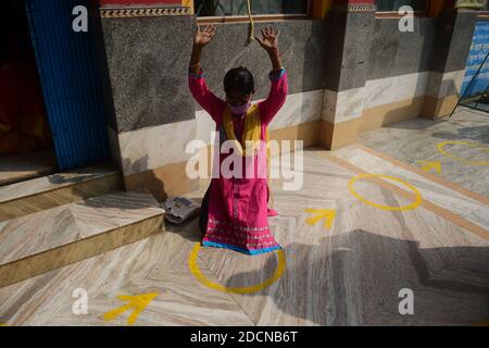 I devoti eseguono rituali durante il Govardhan Puja chiamato anche Annakut (mucchio di grano) in un tempio ad Agartala. Annakut Puja è celebrato con l'adorazione delle mucche così come il giorno Krishna ha sconfitto Indra prendendo la collina di Govardhan. Quest'anno la gestione del tempio permise meno devoti e segnò il pavimento per garantire la distanza sociale per prevenire la diffusione di COVID-19. Agartala, Tripura, India. Foto Stock