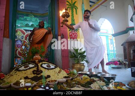 I devoti eseguono rituali durante il Govardhan Puja chiamato anche Annakut (mucchio di grano) in un tempio ad Agartala. Annakut Puja è celebrato con l'adorazione delle mucche così come il giorno Krishna ha sconfitto Indra prendendo la collina di Govardhan. Quest'anno la gestione del tempio permise meno devoti e segnò il pavimento per garantire la distanza sociale per prevenire la diffusione di COVID-19. Agartala, Tripura, India. Foto Stock