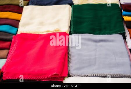 Pila di bright multi-colore di pezzi di tessuto in un bazar Foto Stock