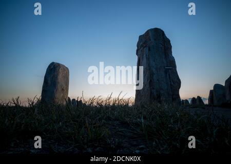 Foto serale al crepuscolo di Ales Stenar, monumento megalitico in pietra, preso da una prospettiva bassa. Foto Stock