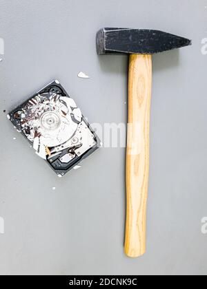 Piatto frantumato nel disco rigido del computer e un martello. Foto Stock