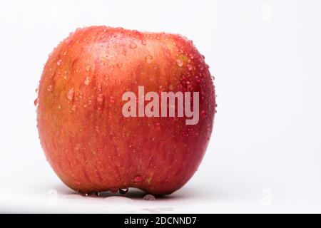 Rosso mela variegato e giallo con gocce d'acqua su sfondo bianco. Concetto di salute e freschezza Foto Stock