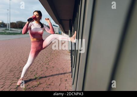 Ragazza sportiva che beve acqua dalla bottiglia Foto Stock