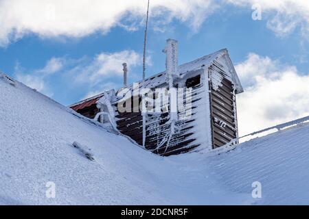 Tetto coperto da ghiaccio e neve su sfondo blu cielo, montagna Zakhar Berkut, Carpazi montagne, Ucraina Foto Stock