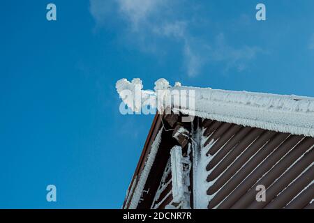 Tetto coperto da ghiaccio e neve su sfondo blu cielo, montagna Zakhar Berkut, Carpazi montagne, Ucraina Foto Stock