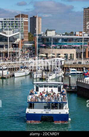 una piccola barca turistica che mostra i visitatori in un viaggio turistico aroun lo storico cantiere a portsmouth. Foto Stock