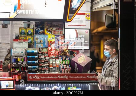 BELGRADO, SERBIA - 26 OTTOBRE 2020: Cliente di un minimarket Kiosk, un uomo che acquista di notte indossando una maschera respiratoria a Belgrado, durin Foto Stock