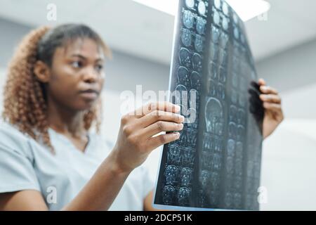 Mano della giovane radiologa africana in uniforme analisi radiologica immagine Foto Stock