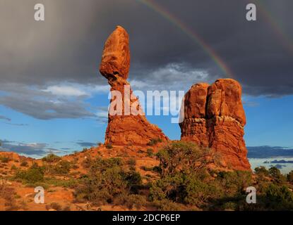 Bella arcobaleno sopra il rosso bilanciato archi di roccia Nazionale Parcheggia nello Utah in UNA giornata estiva soleggiato con un chiaro Cielo blu e alcune nuvole scure Foto Stock