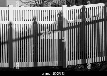 Vista in bianco e nero di recinzione e ombre in stile picket in vinile bianco; Salida; Colorado; USA Foto Stock