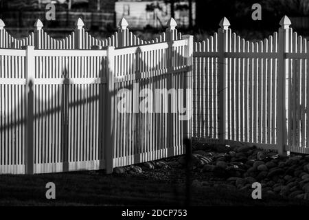 Vista in bianco e nero di recinzione e ombre in stile picket in vinile bianco; Salida; Colorado; USA Foto Stock