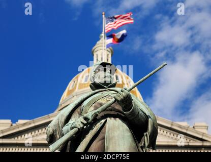 Vista dal basso verso l'alto della statua DI UN soldato in Di fronte allo Shimmerig Golden Dome dello stato del Colorado Campidoglio a Denver in UN giorno estivo soleggiato con UN C Foto Stock