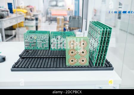 66/5000 scheda madre posizionata su un supporto sopra un tavolo in un'officina Foto Stock