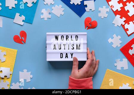 Scatola luminosa portatile, testo Giornata mondiale dell'autismo. Design creativo per il 2 aprile, Autism World awareness day. Elemento puzzle su elementi in feltro stratificati. Piatto Foto Stock