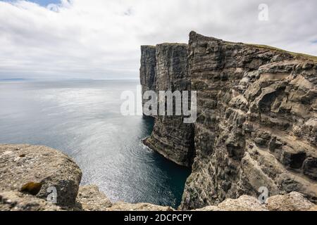 Incredibile scenario di formazioni rocciose vicino a calme acque di mare sotto cielo nuvoloso Foto Stock