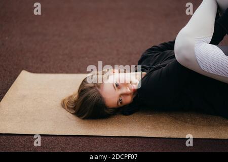 Giovane donna in forma sportiva si allena all'aperto nel parco giochi. Foto Stock