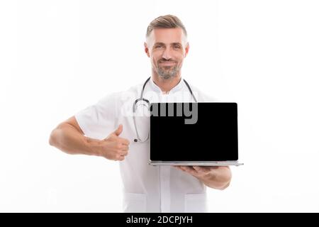 uomo terapeuta con laptop. medico lavoratore con stetoscopio mostrare pollice in su. tecnologia in medicina moderna. prendere un appuntamento con medico online. medico consultazione su covid. Il tuo account personale. Foto Stock