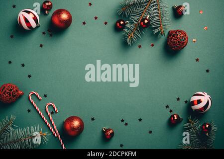 Vintage sfondo natalizio con decorazione a palle rosse e bianche, rami di abete, canne caramelle, confetti. Modello di carta di Natale retrò. Foto Stock