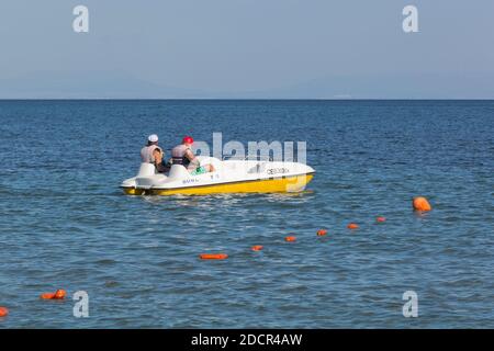 Zaozyornoye, Evpatoria, Crimea, Russia - 23 luglio 2020: Gli uomini navigano dalla spiaggia di Barabulka su un pedalò nel Mar Nero, Crimea Foto Stock