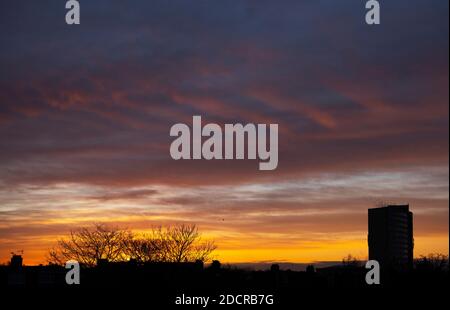 Merton, Londra, Regno Unito. 23 novembre 2020. Dawn si rompe sopra i tetti con il cielo nuvoloso colorato e un chiaro gelo terra nel sud-ovest di Londra Borough di Merton. Credit: Malcolm Park/Alamy Live News. Foto Stock