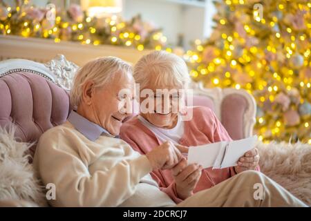 Coppie anziane che guardano attraverso vecchie fotografie Foto Stock