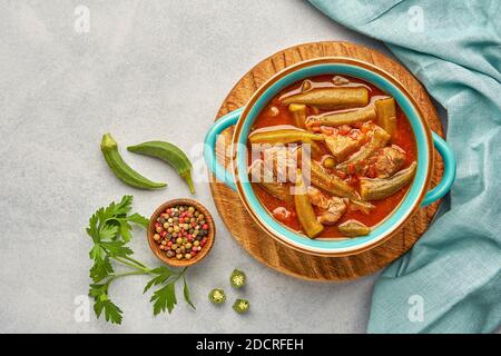 Okra e stufato di carne fatti in casa in una pentola. Vista dall'alto, spazio di copia Foto Stock