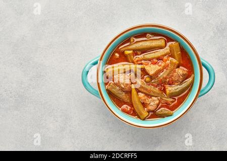 Okra e stufato di carne fatti in casa in una pentola. Vista dall'alto, spazio di copia Foto Stock