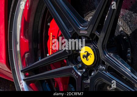 Particolare di una Ferrari rossa con la pinza del freno rossa, parte del cerchio compreso il Cavallino Rampante, uno stallone nero a balza sullo scudo giallo. Foto Stock