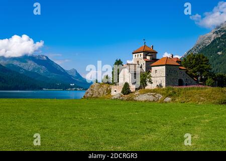 Il Castello Crap de Sass si trova presso il Lago Silvaplana, montagne intorno a Piz Corvatsch in lontananza. Foto Stock