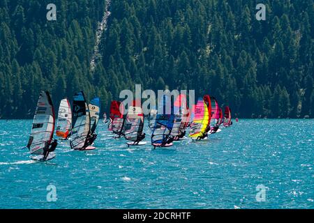 Un gruppo di surfisti del vento con vele colorate sta navigando sul Lago Silvaplana. Foto Stock